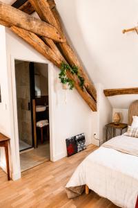 a bedroom with a white bed and wooden beams at Le Grenier - Air conditioning - Free parking in Nogent-sur-Vernisson