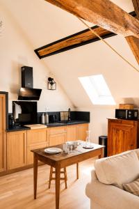 a living room with a table and a kitchen at Le Grenier - Air conditioning - Free parking in Nogent-sur-Vernisson