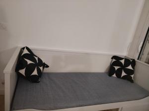 two black and white pillows sitting on a bed at Renovated studio in Le Crès in Le Crès