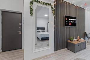 a hallway with a mirror and a bed in a room at Crina Studio in Bragadiru
