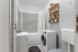 a white bathroom with a washing machine in it at Crina Studio in Bragadiru