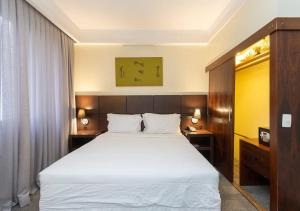 a bedroom with a large white bed and two tables at Alojamiento Center in Barraquero