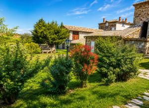 a garden in front of a house with bushes at "La Voûte de Pierre" Gîte indépendant in Saint-Cyr