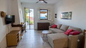 a living room with a couch and a tv at Endless Blue Maisonette in Agios Ioannis Pelio