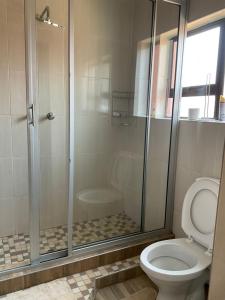 a bathroom with a glass shower with a toilet at Zahara Lodge in Victoria Falls