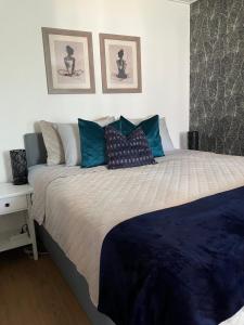 a bedroom with a large bed with blue pillows at Alvooria Living in Tapa