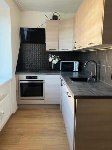 a kitchen with white cabinets and a sink at Alvooria Living in Tapa