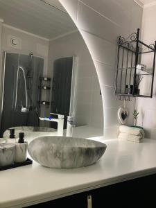 a bathroom with a marble sink and a mirror at Alvooria Living in Tapa