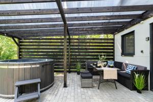 a patio with a hot tub and a wooden pergola at Ale Jazz w cenie jacuzzi i basen in Nowe Miasto
