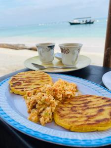 a plate of breakfast food with toast and two cups at Vista Linda Cabaña in Playa Blanca