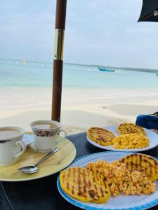 a table with two plates of food and two cups of coffee at Vista Linda Cabaña in Playa Blanca