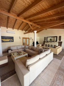 a living room with white furniture and a wooden ceiling at Luxury Villa near Vila Sol Golf Resort - Pool & Garden in Quarteira