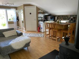 a living room with a couch and a kitchen at Lugnet på landet! in Töllsjö