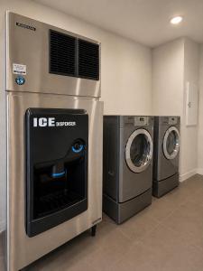 two washing machines and a washer and dryer in a room at Hotel Royale - Houston Hobby Airport in Houston