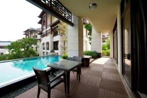 a patio with a table and chairs next to a swimming pool at Imperial Springs in Conghua