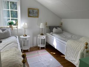 a bedroom with two beds and two lamps and a window at Lugnet på landet! in Töllsjö