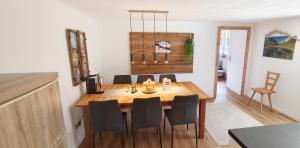 a dining room with a wooden table and chairs at Haus am Seebach Leutasch Weidach in Leutasch +25 photos