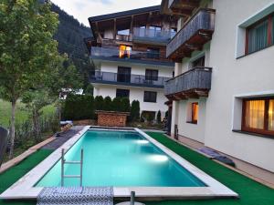 an apartment with a swimming pool in front of a building at Doff-Sotta Appartements in Sankt Anton am Arlberg