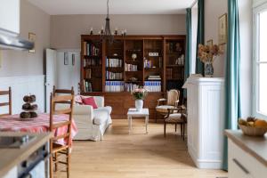 a kitchen and living room with a couch and chairs at Gîte de LA CHESNAYE in Cerelles