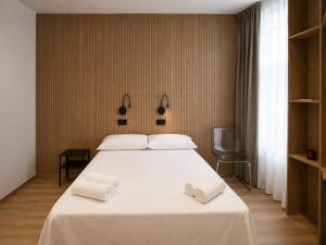 a bedroom with a large white bed with towels on it at Welcome Hostel in Churriana