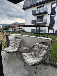 two chairs sitting on a patio in front of a building at Piatra Studio Garden in Piatra Neamţ