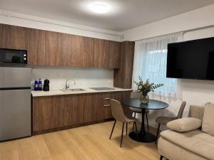 a kitchen and living room with a table and a couch at Piatra Studio Garden in Piatra Neamţ