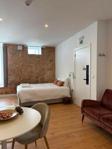 a room with a bed and a table and a couch at Sobrado das Marias in Figueiró dos Vinhos +44 photos