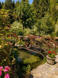 a wooden bridge with a table and bench and flowers at Weekend house Grahovača in Rožaje