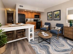 a kitchen and living room with a counter and chairs at Royal Kahana 318 Studio Condo in Kahana