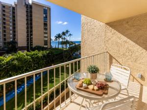 a table with a plate of fruit on a balcony at Royal Kahana 318 Studio Condo in Kahana