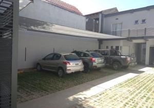 two cars parked in a garage next to a building at Alojamiento Center in Barraquero