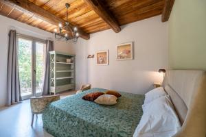 a bedroom with a bed with a blue bedspread at Casale21 in Castiglion Fiorentino