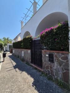 a fence with flowers on it next to a building at Casa Cachepot - Sweet Silvana in Ischia