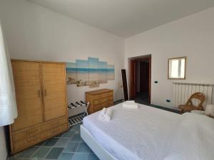 a bedroom with a large bed and a wooden cabinet at Casa Cachepot - Sweet Silvana in Ischia