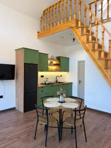a kitchen with green cabinets and a table with chairs at Calm Barnhouse Lankaran in Lankaran