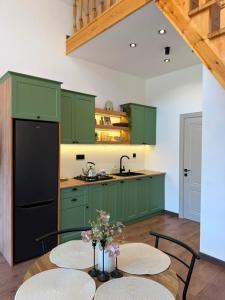 a kitchen with green cabinets and a table with chairs at Calm Barnhouse Lankaran in Lankaran