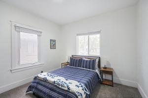 a bedroom with a bed and two windows at Ogden Base Camp in Ogden