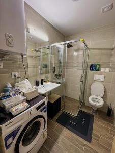 a bathroom with a washing machine and a sink at Apartman Mario in Čačak +11 photos