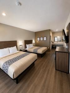 a hotel room with two beds and a bathroom at Hotel Royale - Houston Hobby Airport in Houston