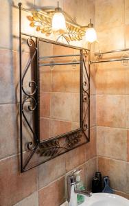 a mirror on a wall above a bathroom sink at Dreamcatcher Maisonette No.2 in Kalavrita +22 photos
