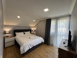 a bedroom with a bed and a large window at Villa Kazbegi in Tkarsheti