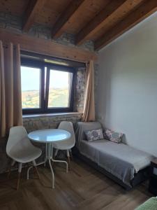 a small bedroom with a bed and a table and a window at La Casona de Regolfo in Regolfo