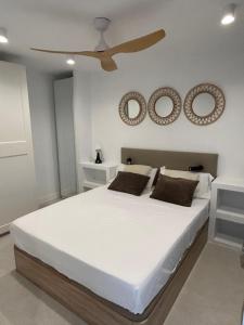 a bedroom with a white bed with a ceiling fan at Rosa de los Vientos 71 Renovado julio 2026 in Mijas Costa +23 photos