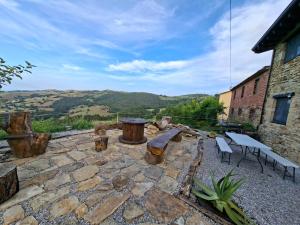 a stone patio with a bench and a table at La Casona de Regolfo in Regolfo