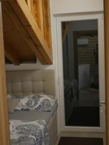 a room with a bed and a door with a mirror at Kuća za odmor Mate 