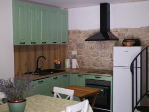 a kitchen with green cabinets and a table at Kuća za odmor Mate 