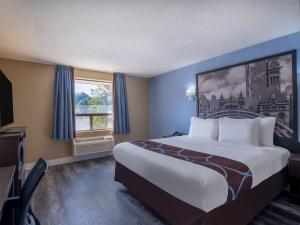 a hotel room with a large bed and a window at Hotel Ramida Suites IGI Delhi Airport in New Delhi