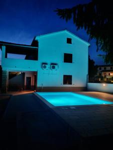 a villa with a swimming pool at night at Hiža Bili in Svetvinčenat