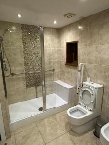 a bathroom with a shower and a toilet and a tub at Plus Properties Leeds 2 in Bradford