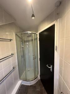 a shower with a glass door in a bathroom at Plus Properties Leeds 2 in Bradford +7 photos